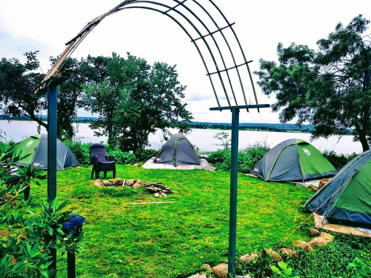 Lakeside tents under bamboo arch at The Wilderness Campsite